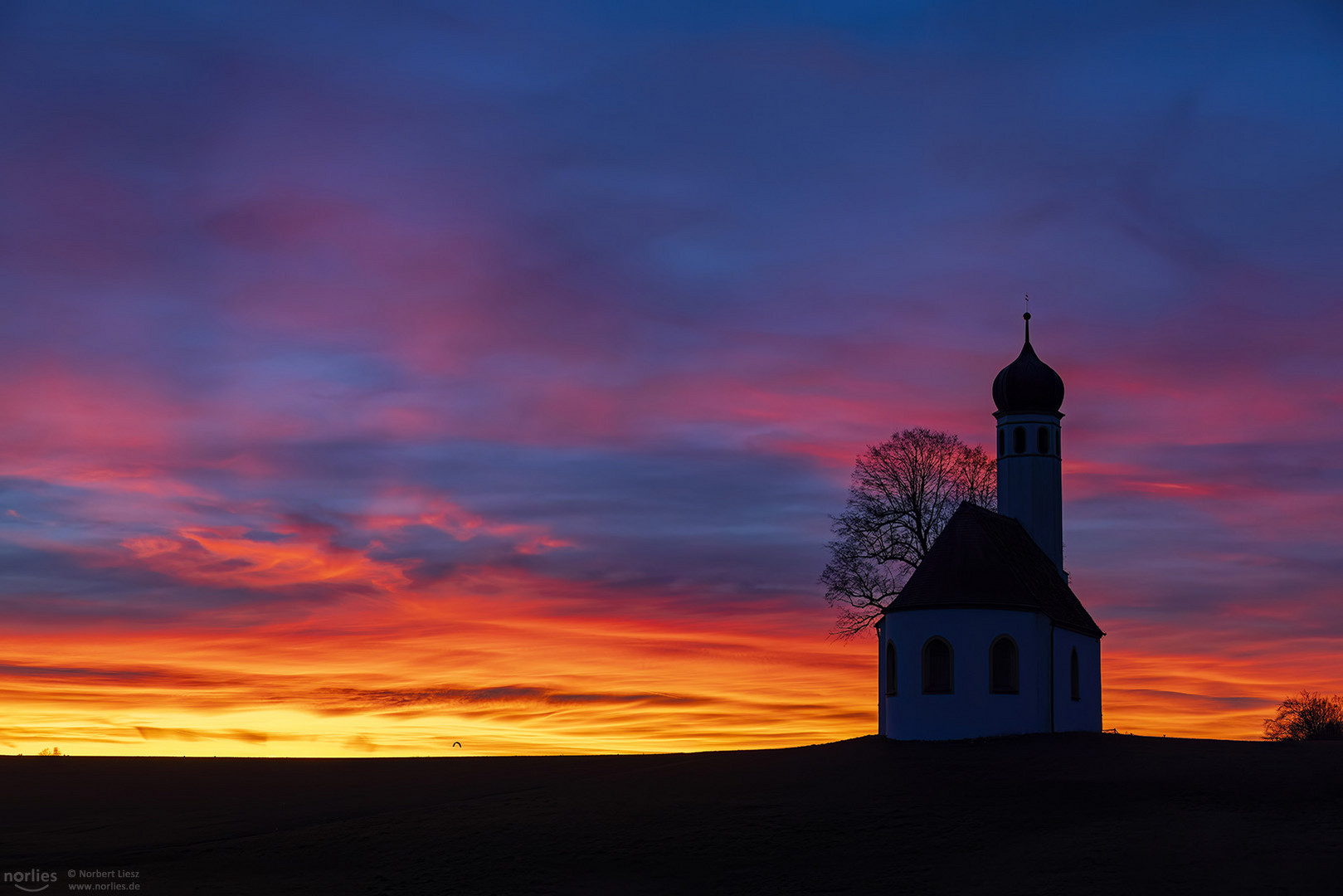 Rot leuchtende Wolken an der Kapelle