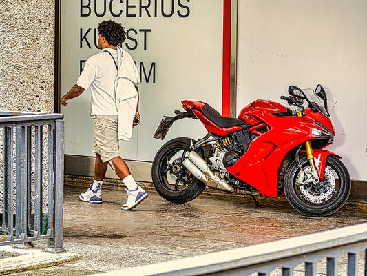 Rote Ducati Kurzparker (Streetfotografie mit Menschen)