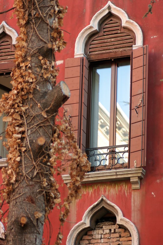 rote Fassade mit Fensterspiegelung in Venedig