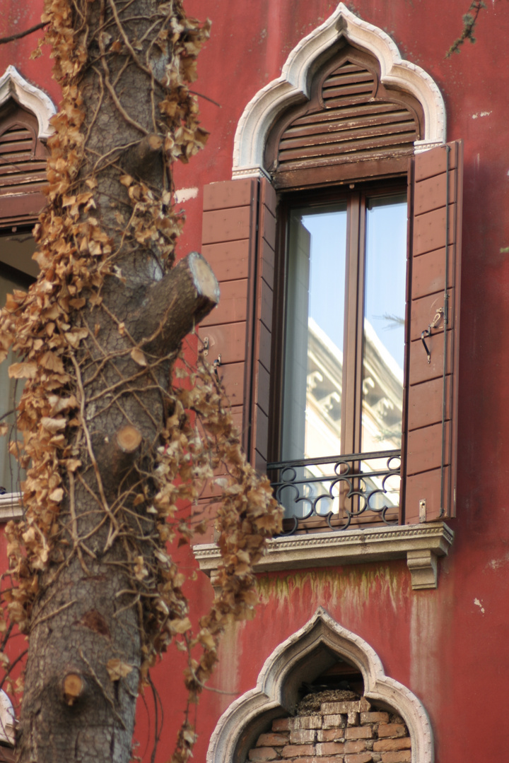 rote Fassade mit Fensterspiegelung in Venedig