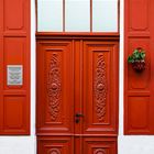 Rote Holztür mit Fensterläden
