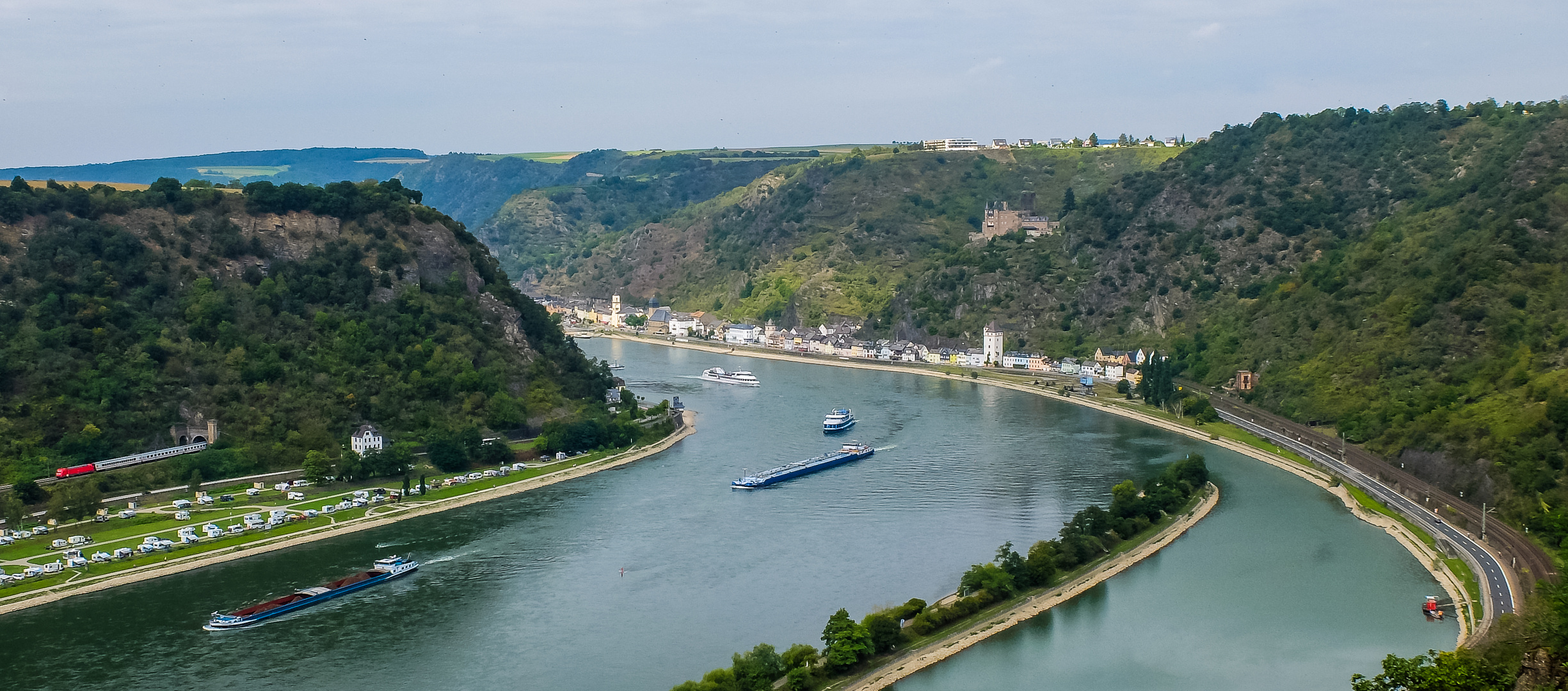 Rote Lok in grüner Flußlandschaft