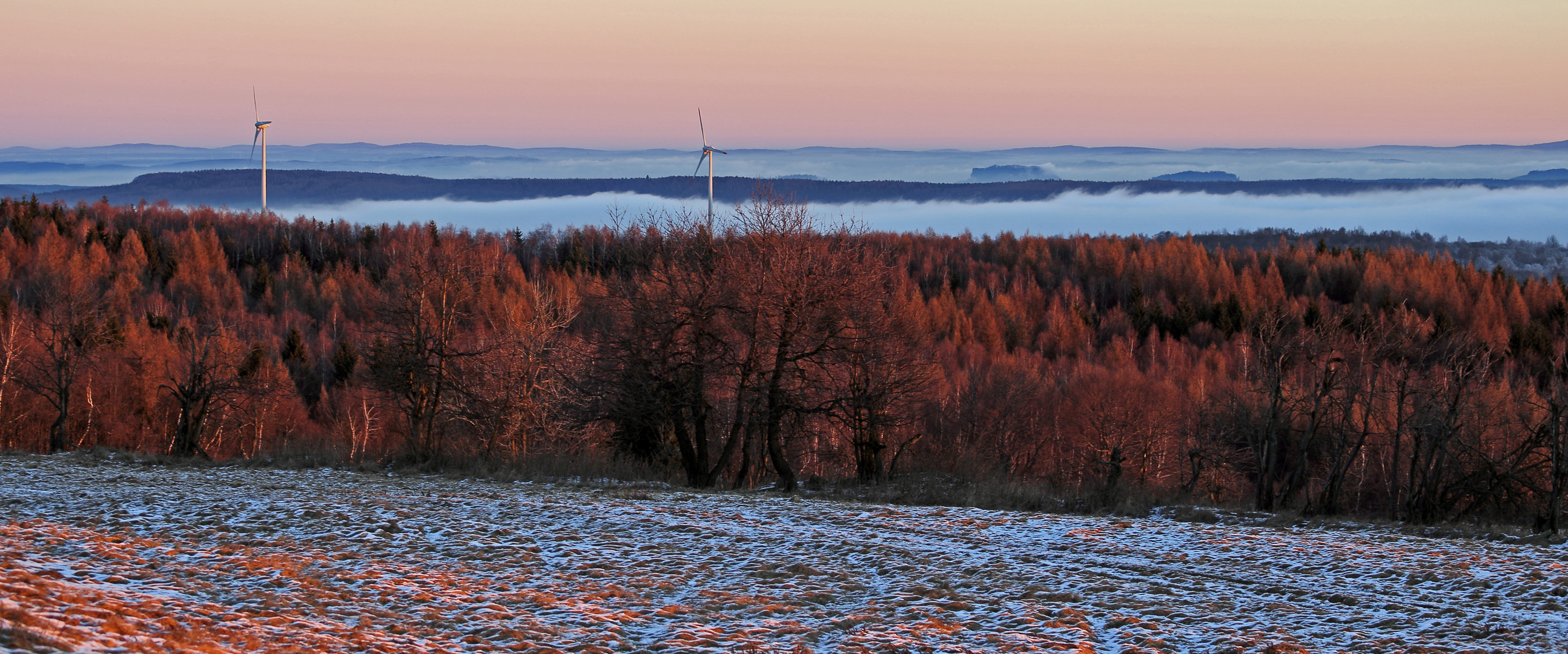 Rote Silvestermorgensonne auf Wäldern und Gipfeln über dem Nebel...