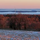 Rote Silvestermorgensonne auf Wäldern und Gipfeln über dem Nebel...