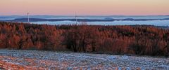 Rote Silvestermorgensonne auf Wäldern und Gipfeln über dem Nebel...