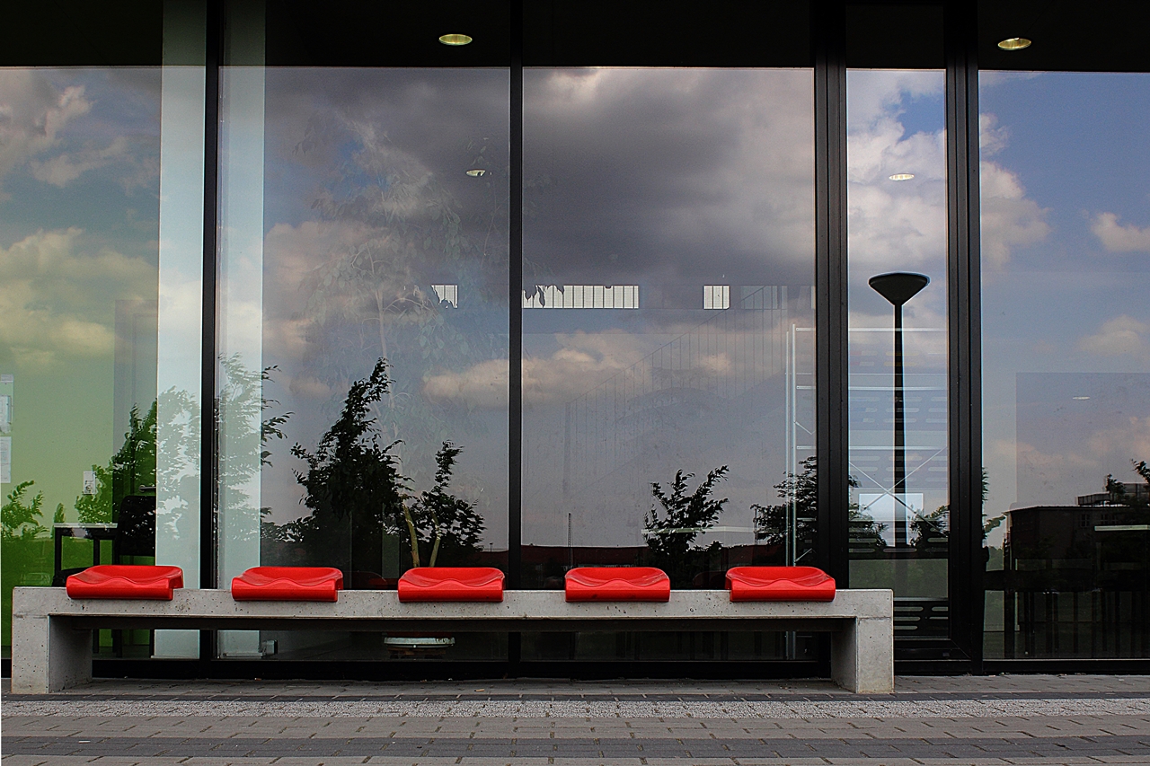 Rote Sitze vor spiegelnder Fassade