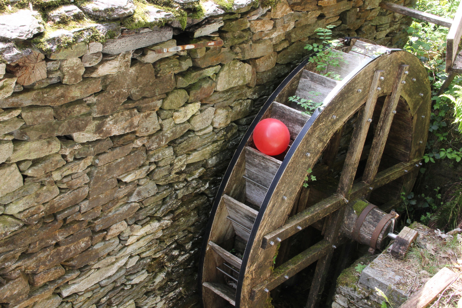 Roter Ballon im Wasserrad