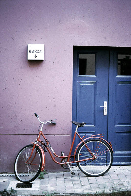 rotes fahrrad, blaue tür, lila wand