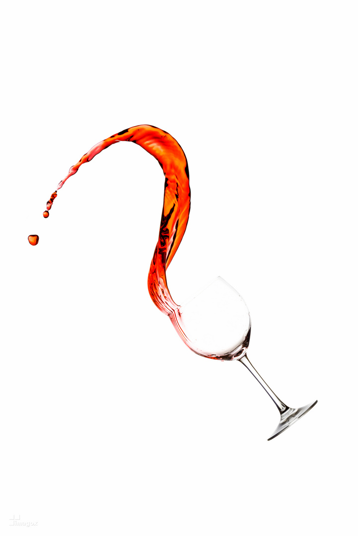 Rotwein wird aus einem Glas gespritzt
