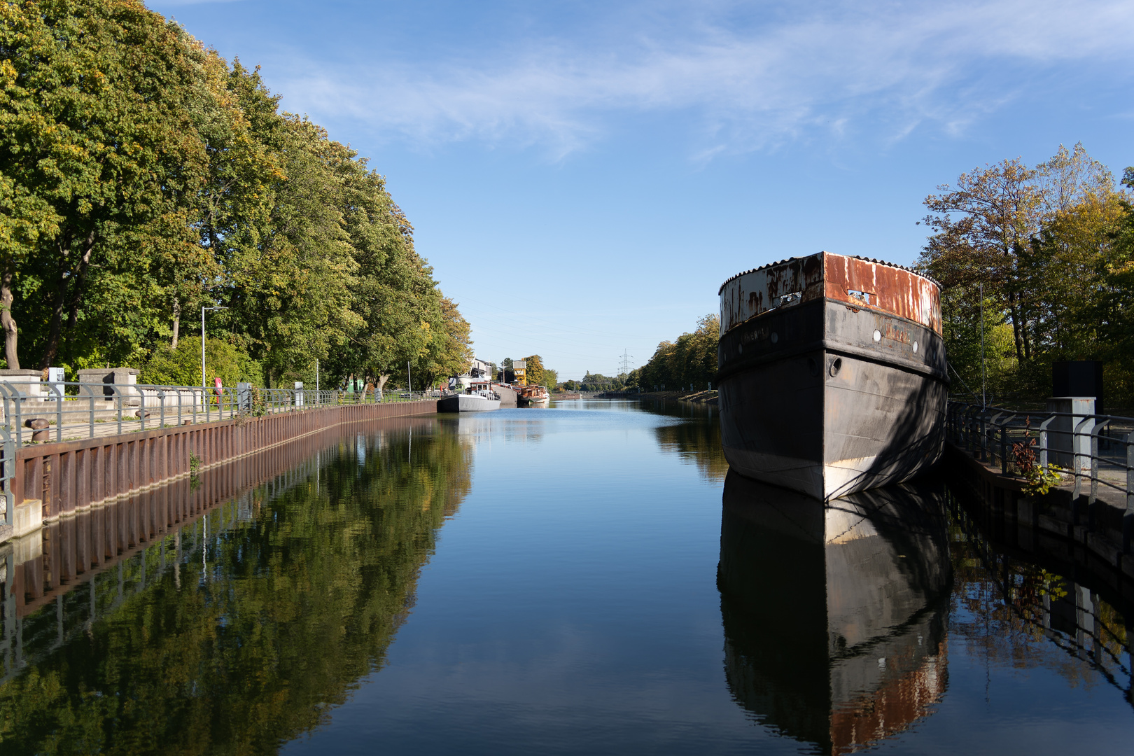 Ruhig spiegelt sich das Sonnenlicht und die Schiffe im Kanal