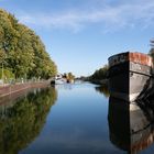 Ruhig spiegelt sich das Sonnenlicht und die Schiffe im Kanal