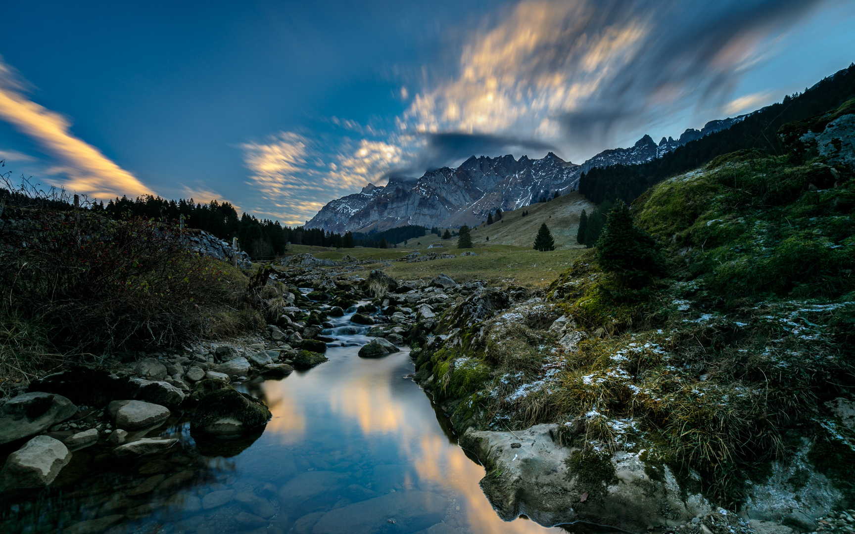 Ruhiges Wasser und fliegende Wolken