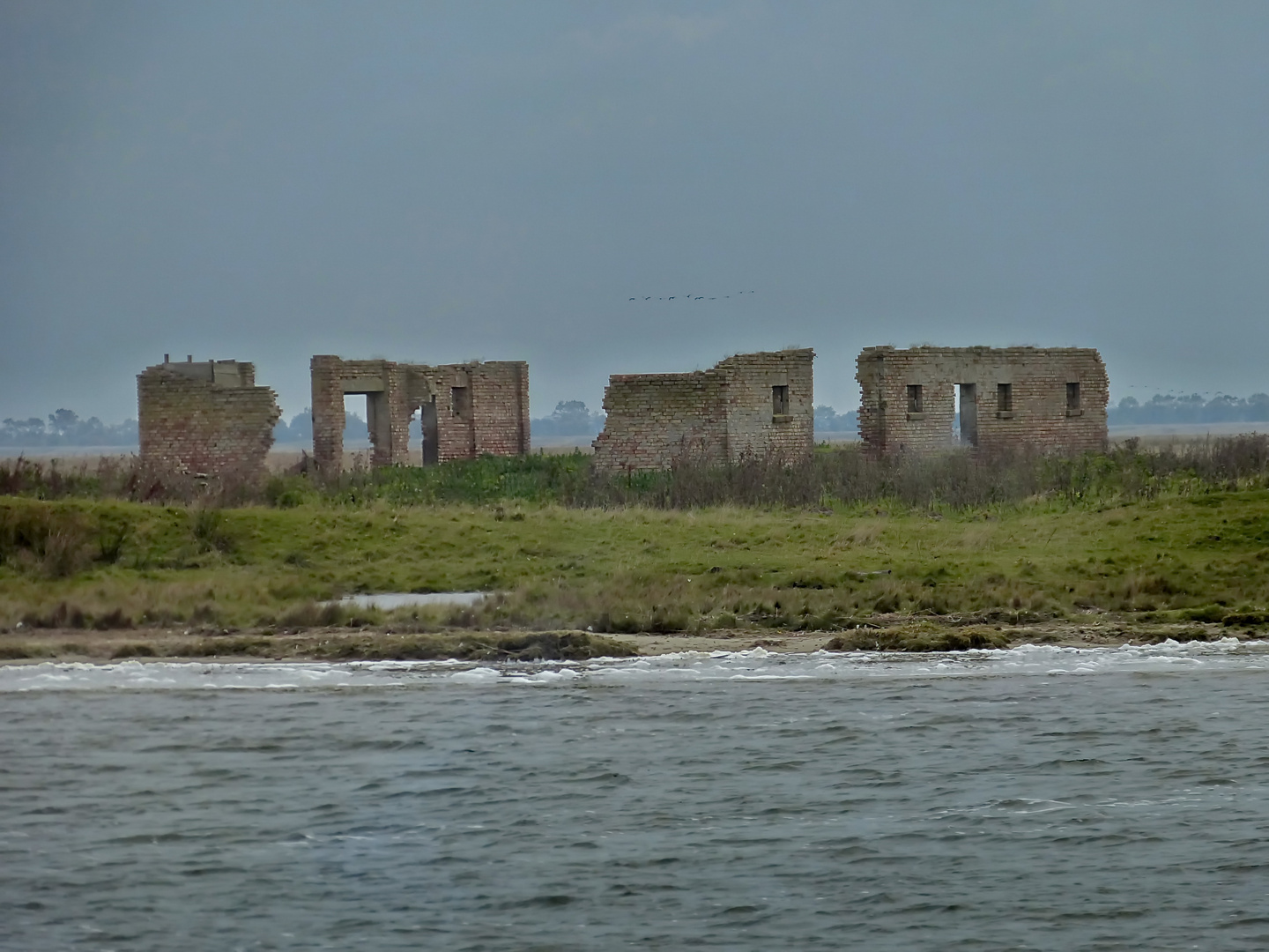 Ruine eines Bauernhofes auf der Insel Kirr vom Schiff aus gesehen