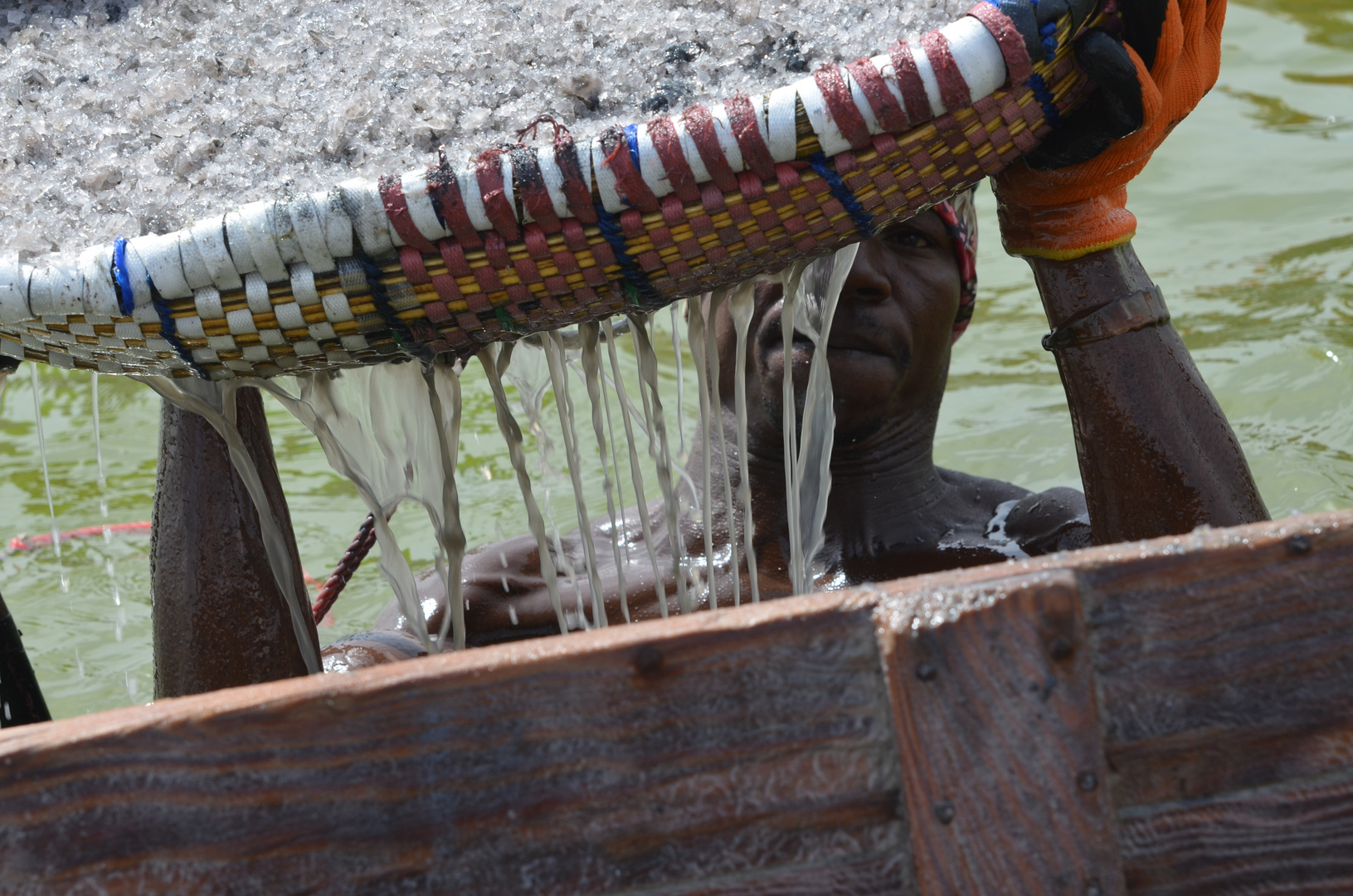 Salzfischer auf dem Lac rose hievt das mühsam gewonnene Salz ins Boot. (Senegal)