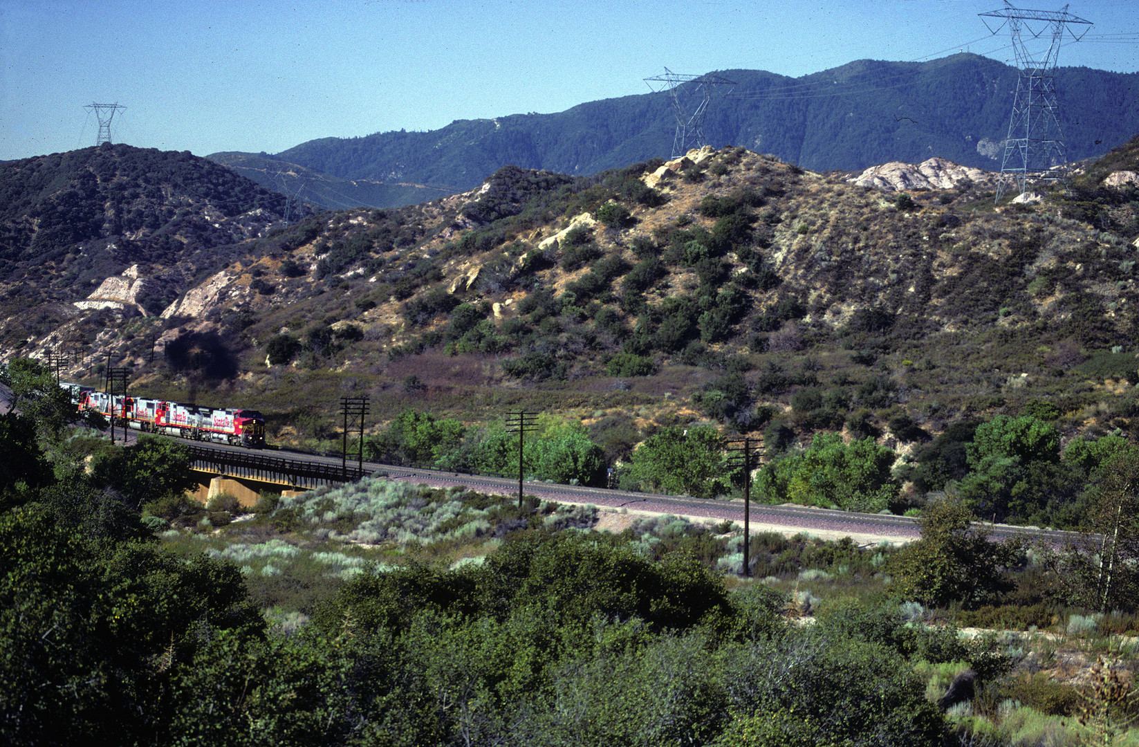 Santa Fe ATSF red wb Locos are pulling a Trailer Train close to Rte.66,CA