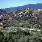 Santa Fe ATSF red wb Locos are pulling a Trailer Train close to Rte.66,CA