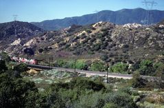 Santa Fe ATSF red wb Locos are pulling a Trailer Train close to Rte.66,CA