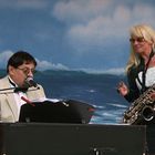 Saxophonistin mit Pianist am Meer