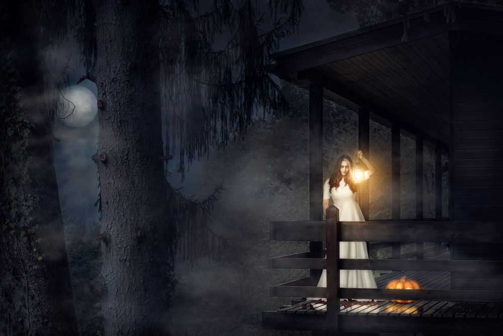 Scary woman in white dress in a dark forest