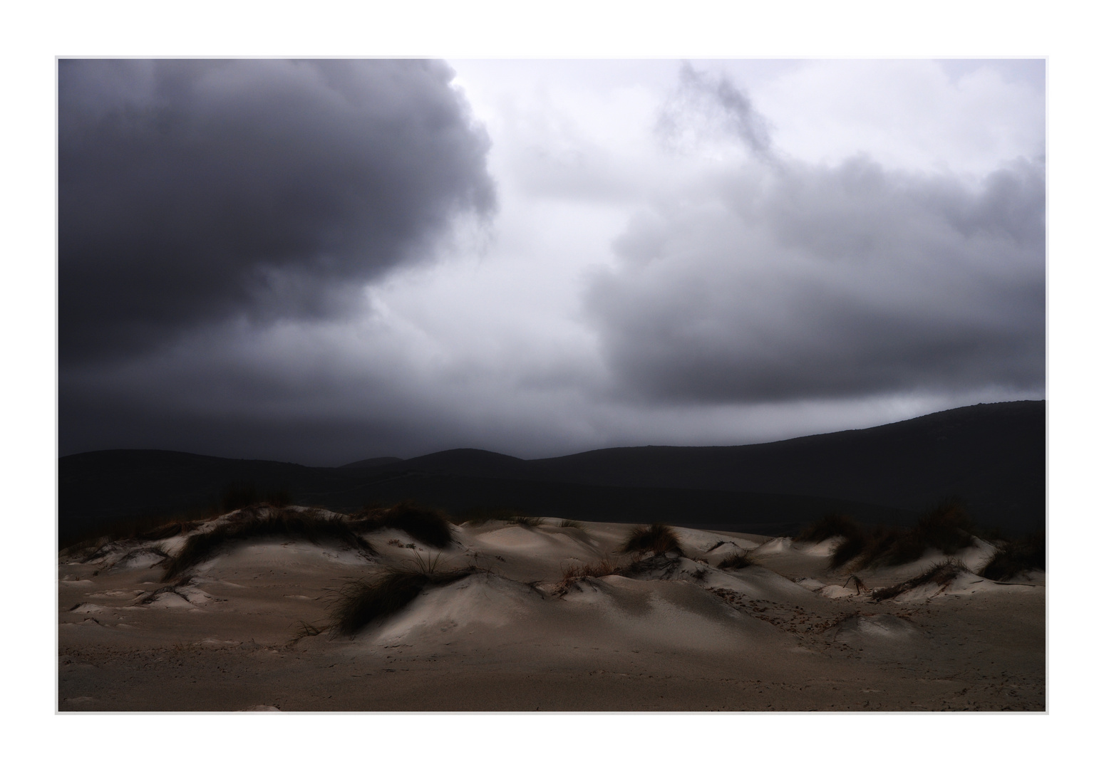 scharzgraue wolken über weißen dünen ...