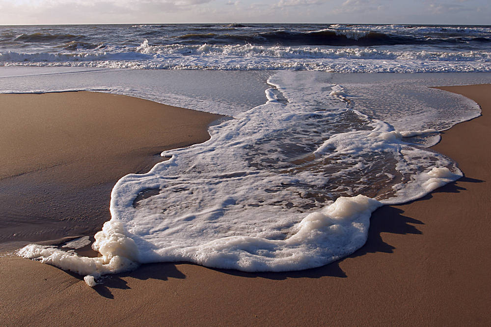 Schaummuster im Abendlicht am Strand von Sylt