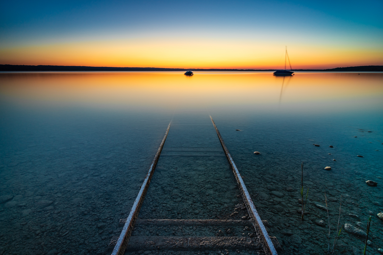 Schienen im Ammersee bei Sonnenuntergang