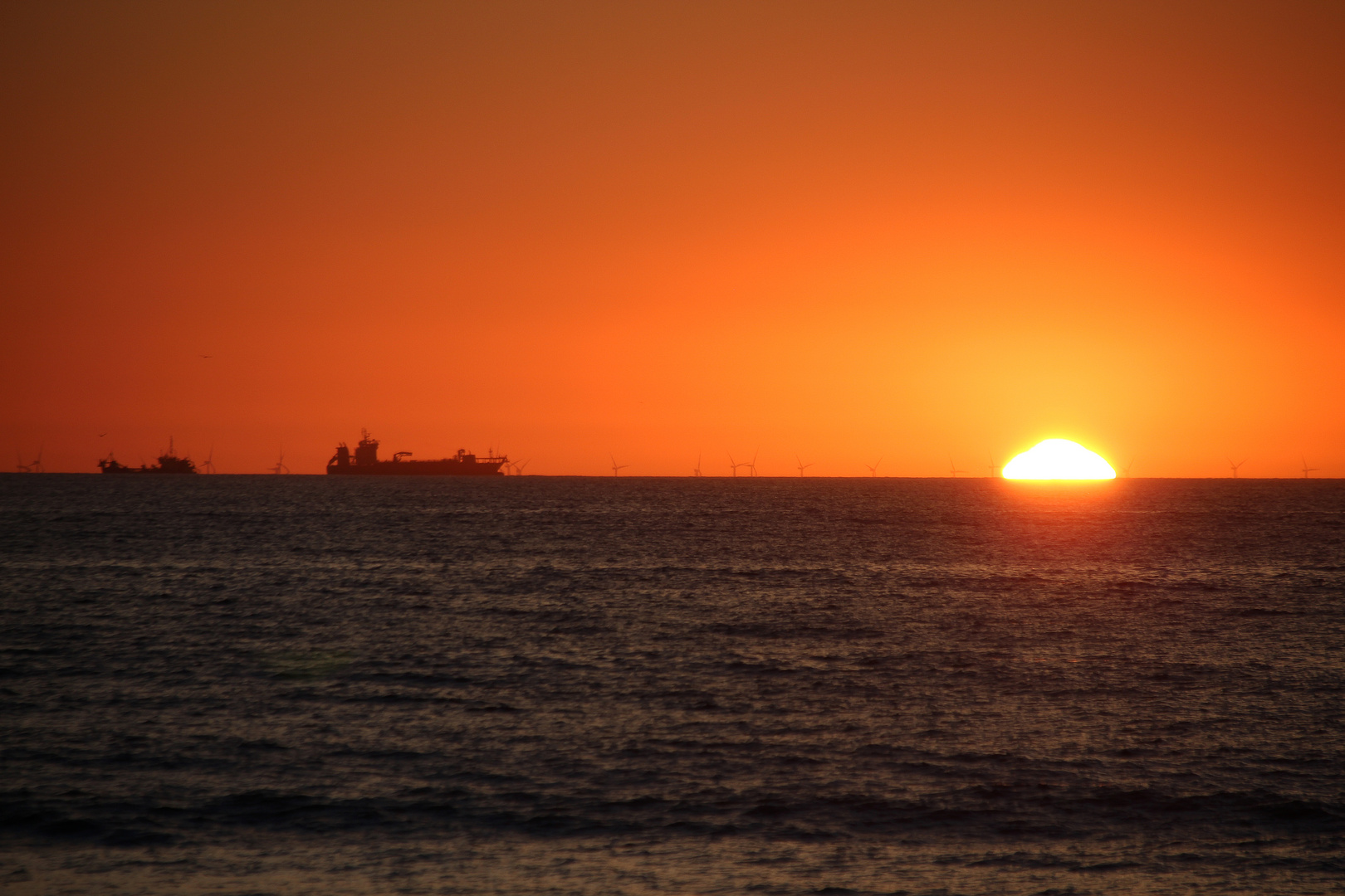 Schiffe und Windräder am Horizont