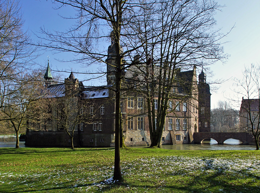 Schloss Derfeld hinter Bäumen.