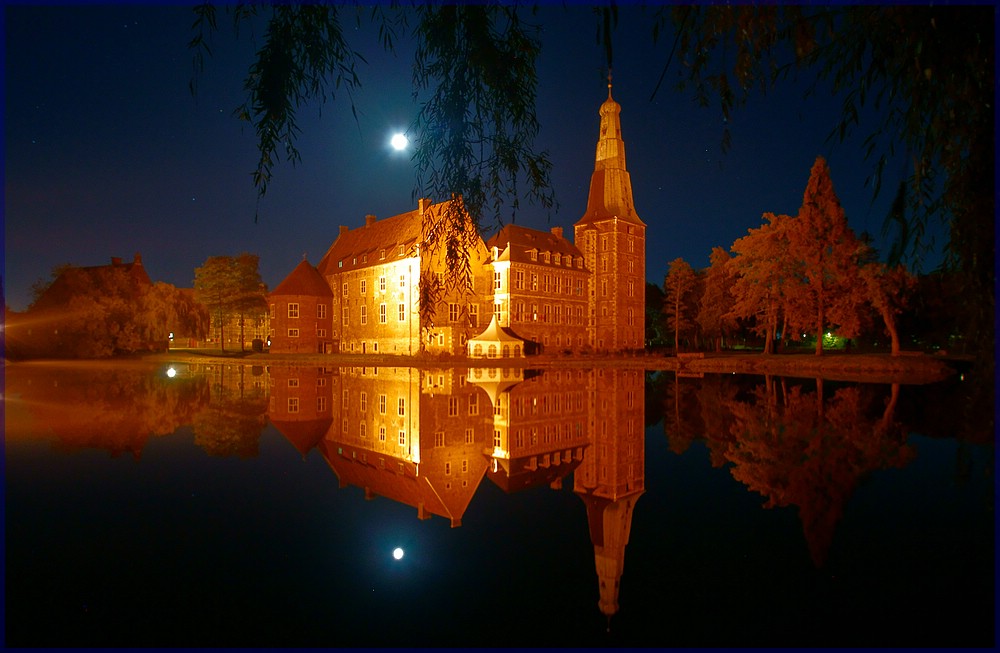 Schloss Raesfeld nachts im Spiegel des Sees