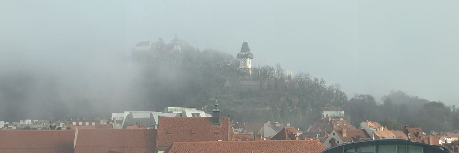 Schlossberg mit Uhrturm im Nebel