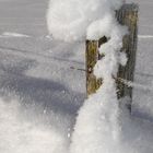 Schnee auf Zaunpfahl