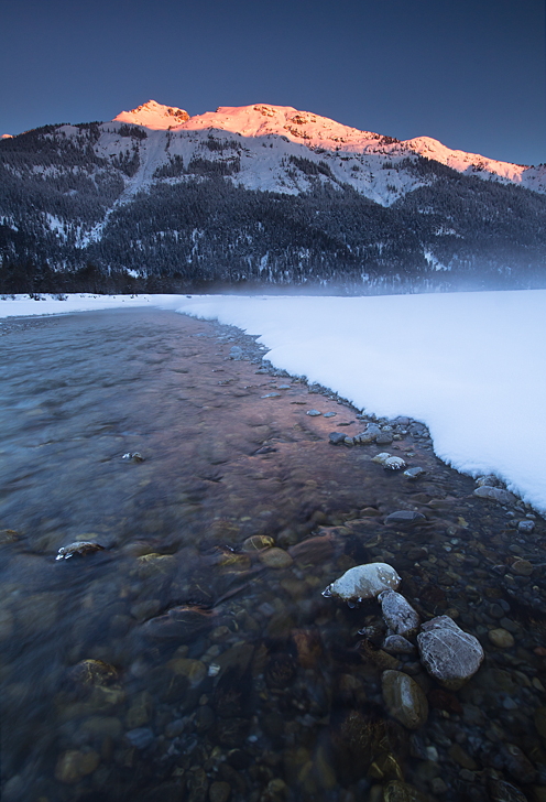 Schnee, Wasser und Berge beim ersten Licht