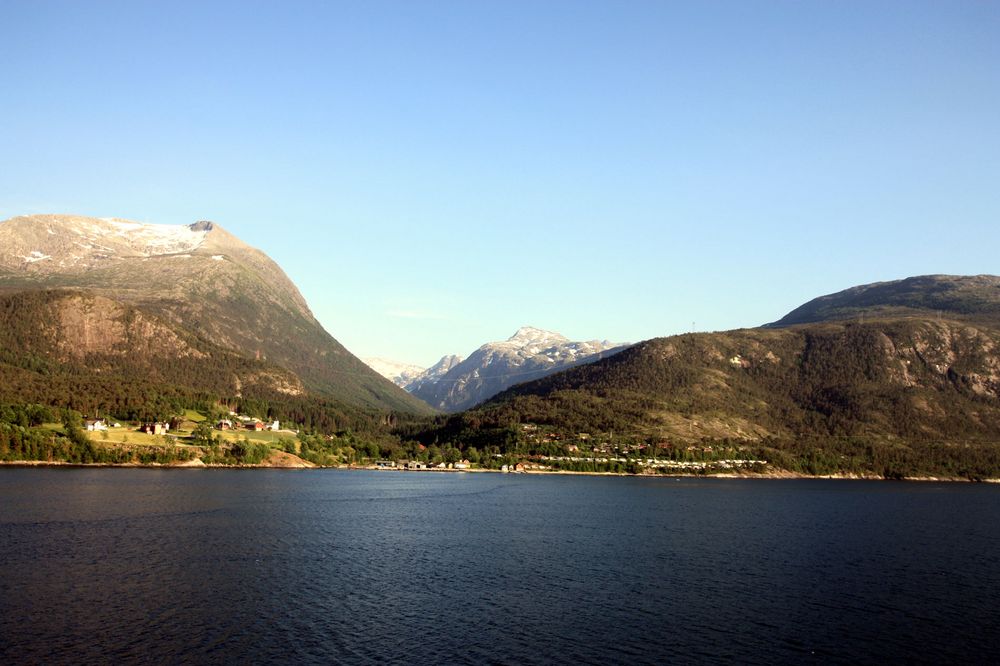 schneebedeckte Berge am Fjord im Mai