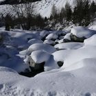 schneebedeckter Bachlauf