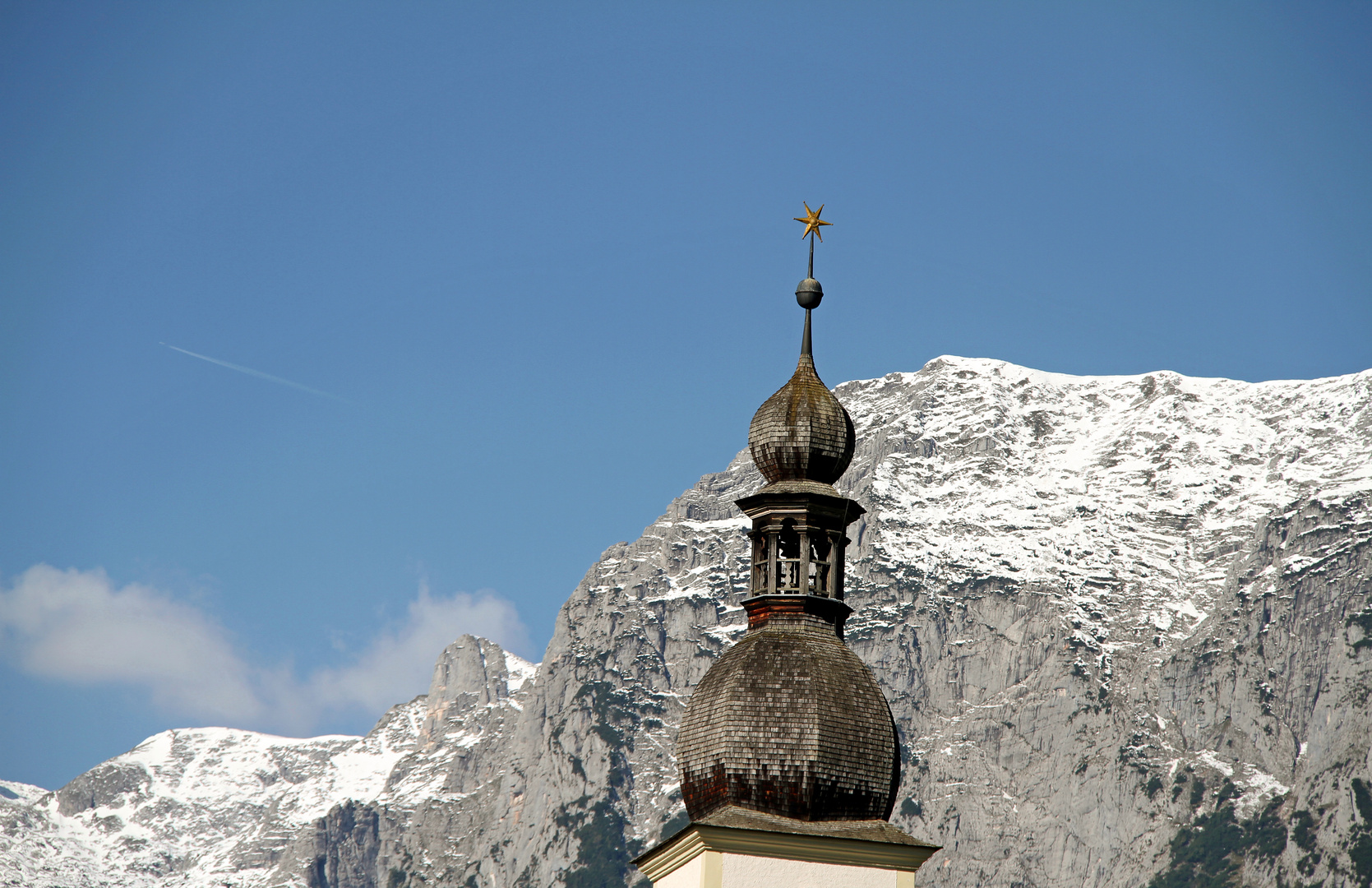 Schneebedeckter Watzmann im Vordergrund die Kirchturmspitze vom malerischen Kirche in Ramsau