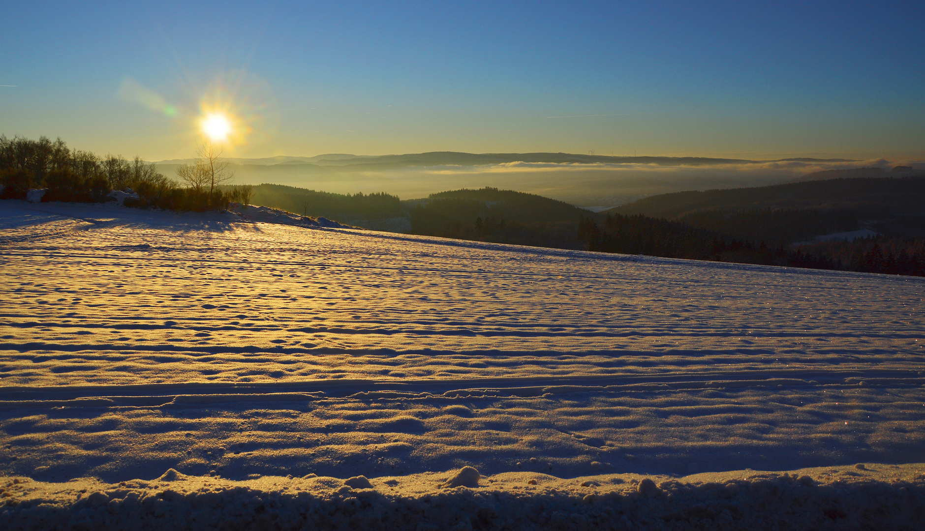 schneebeglänztes Feld bei Sonnenaufgang