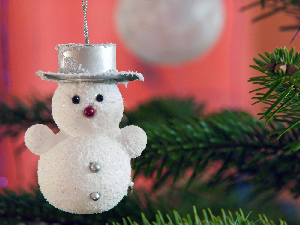 Schneemann hängt am Weihnachtsbaum