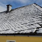 Schneemuster auf dem Naturschiefer unter blauem Himmel