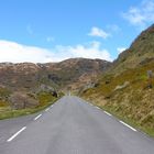 Schnurgerade Strasse durch ein Tal, Serpentinen den Berg hinauf