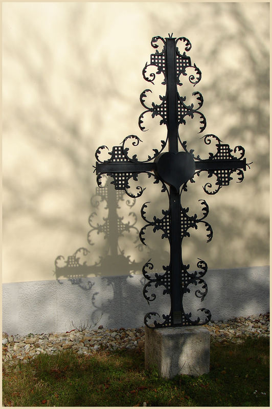 Schönes schattenwerfendes kreuz das an der mauer einer kirche steht