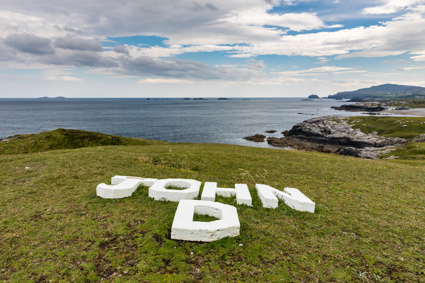 Schriftzeichen im Gras an der Küste am Malin Kopf