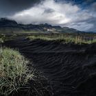 Schwarzer Sand und tiefe Wolken