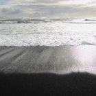 Schwarzer Sand und Wasser