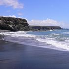 Schwarzer Strand mit Felsen