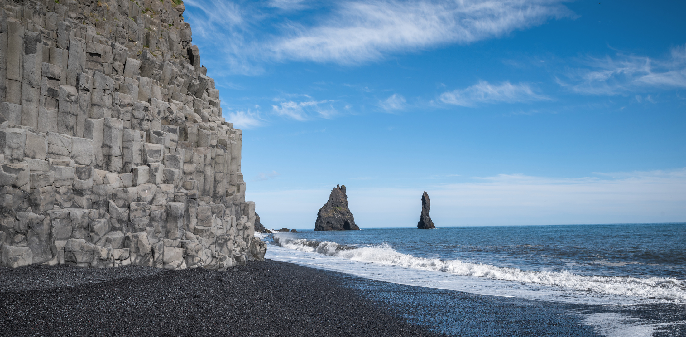 Schwarzer Strand und Basaltfelsen