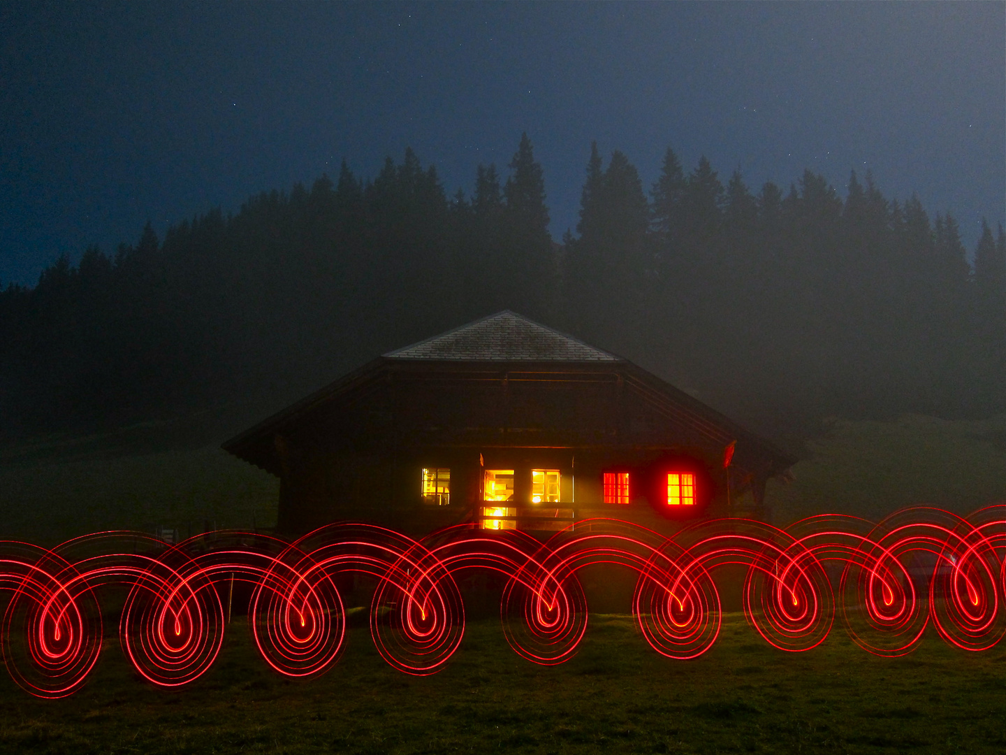 schwarzmooshütte mit rotem lichtornament