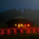 schwarzmooshütte mit rotem lichtornament