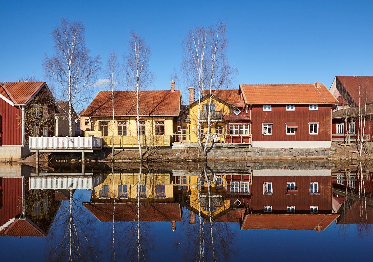 Schwedenhäuser spiegeln sich im Wasser in Falun (Dalarnas Län / Schweden)