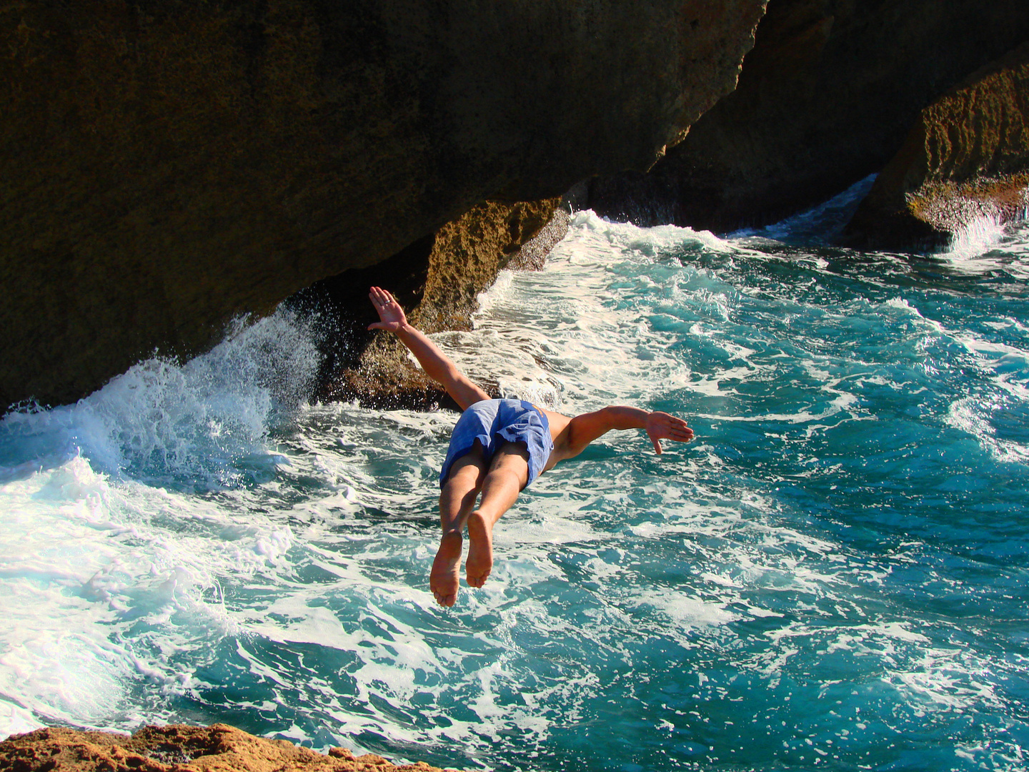 Schwimmer Springt von der Klippe