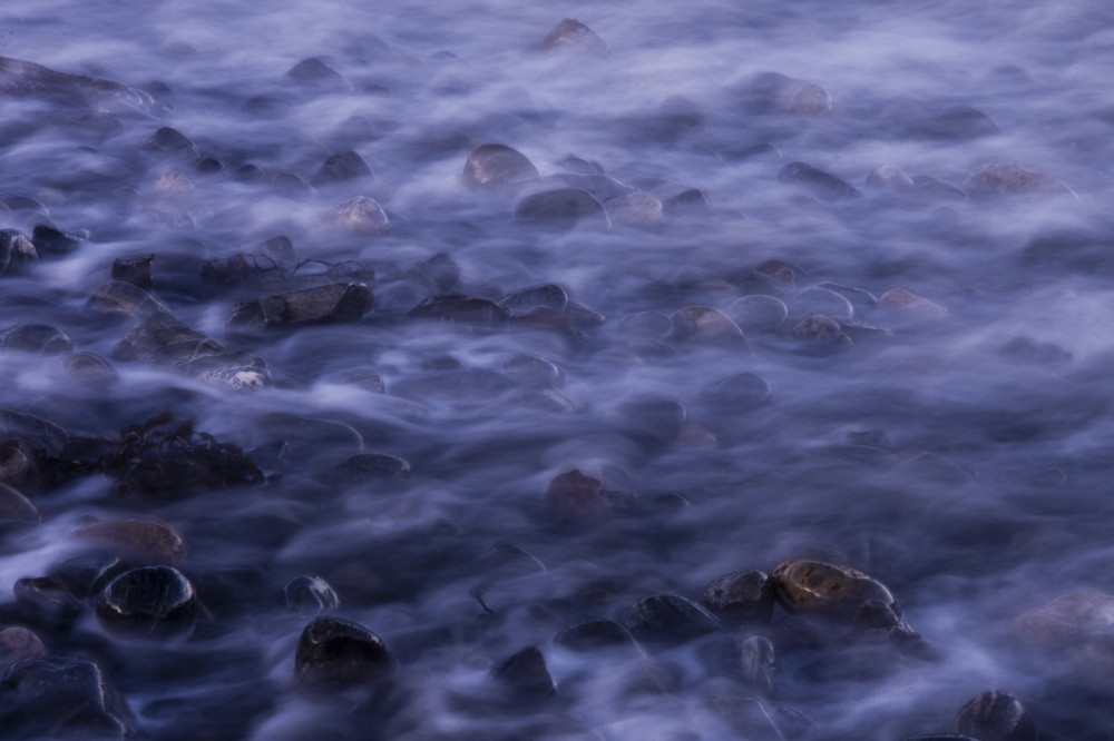 Sea mist over pebbles on the shore